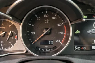 Tableau de bord d'une voiture moderne affichant un compteur de vitesse avec les deux unités km/h et mph