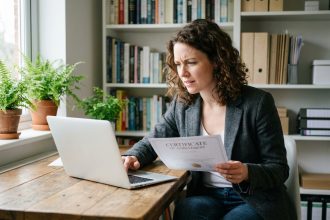 Femme au bureau avec documents et ordinateur